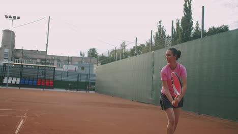 Young-Caucasian-woman-playing-tennis-on-a-court-returning-a-ball-in-slow-motion